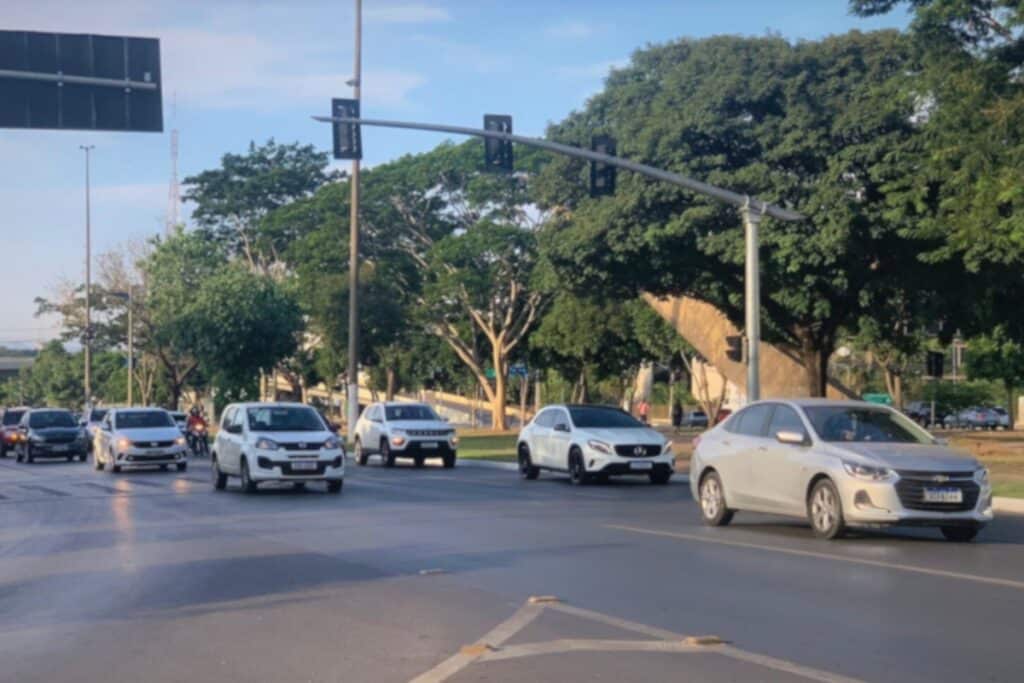 Trânsito movimentado em cruzamento durante o dia.