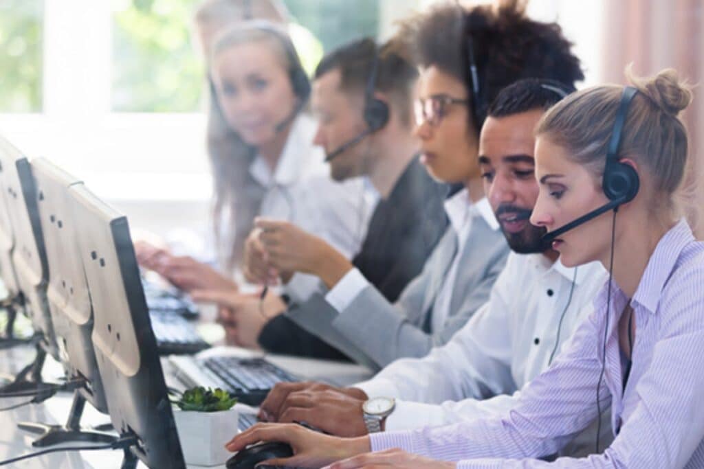 Equipe de atendimento ao cliente trabalhando com headsets.