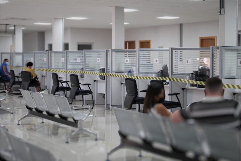 Sala de espera e guichês de atendimento vazios.