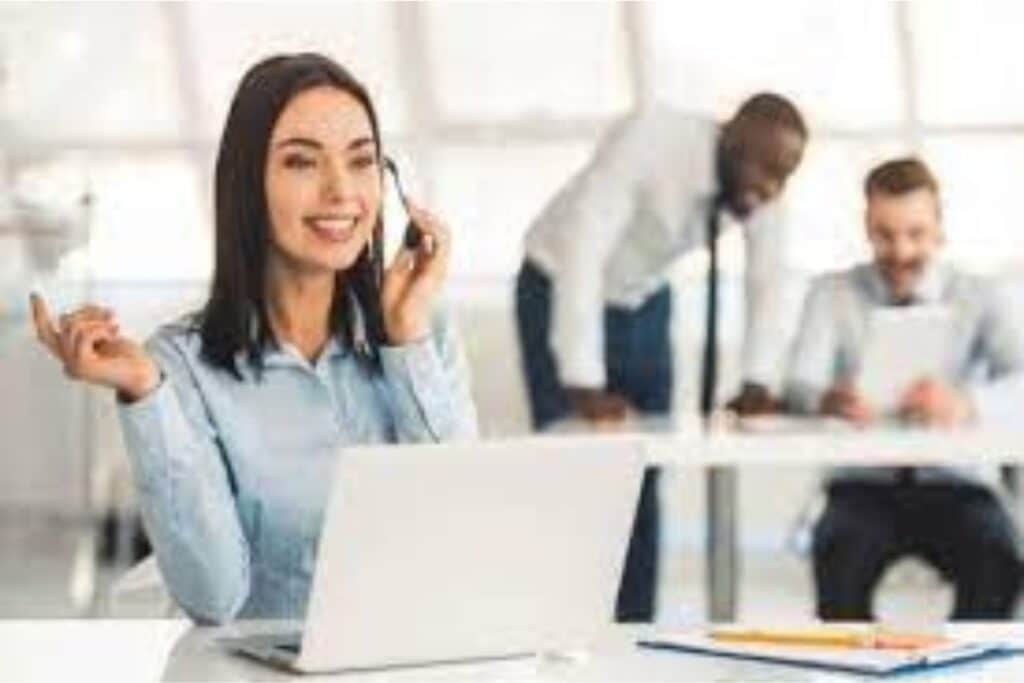 Profissional sorridente ao telefone em escritório.