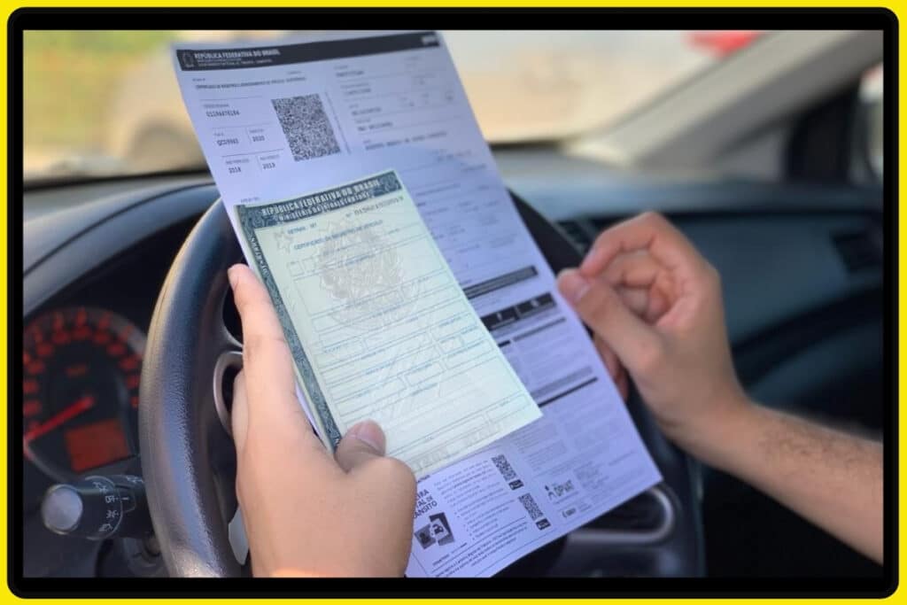 Pessoa segurando CNH e documento de veículo.