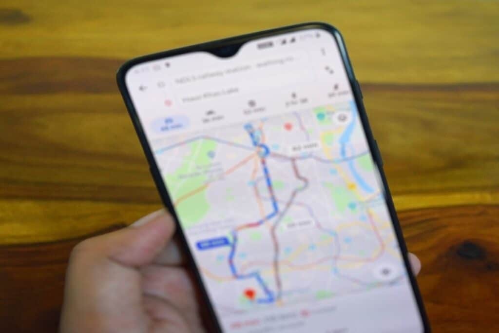 Mão segurando celular com mapa GPS.