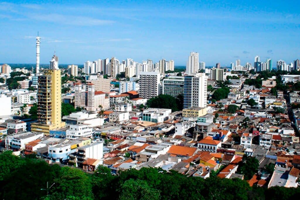 Vista aérea cidade brasileira com prédios e vegetação.