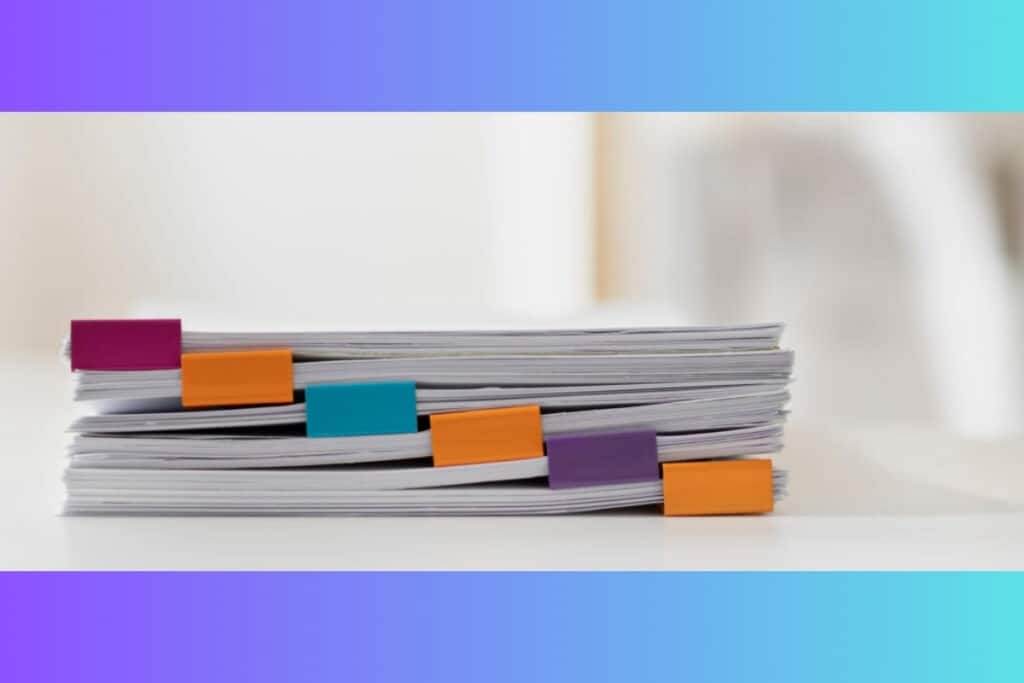 Pilha de documentos com marcadores coloridos.