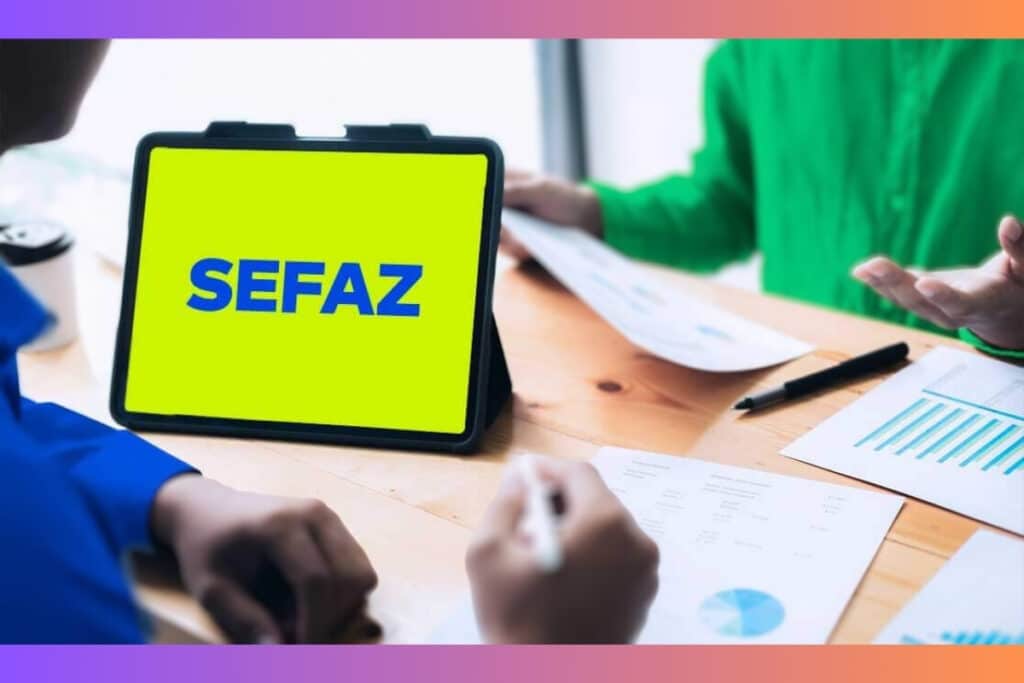 Tablet com logo SEFAZ em reunião de negócios.