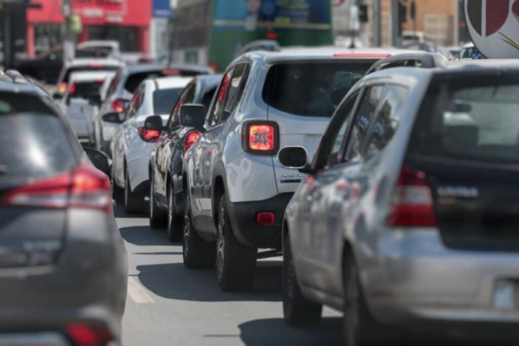 Trânsito intenso com carros em fila na cidade.